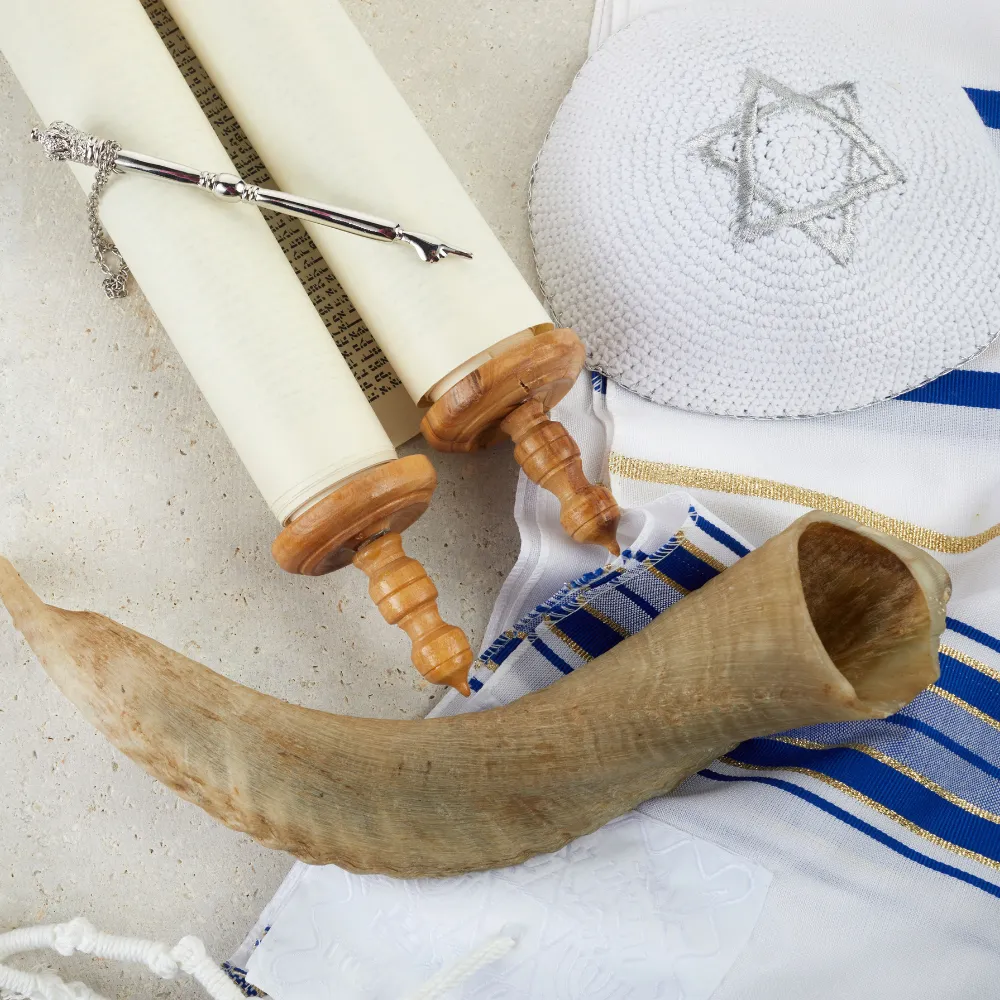 סט כיסוי טלית ותפילין, שופר וכיפה על רקע שולחן שבת. מתנות יודאיקה בעיצוב אישי.