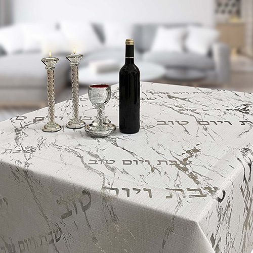 סט שולחן שבת מעוצב עם מפה, פמוטים, גביע יין ובקבוק יין. מתאים למתנות יודאיקה לחתונה.